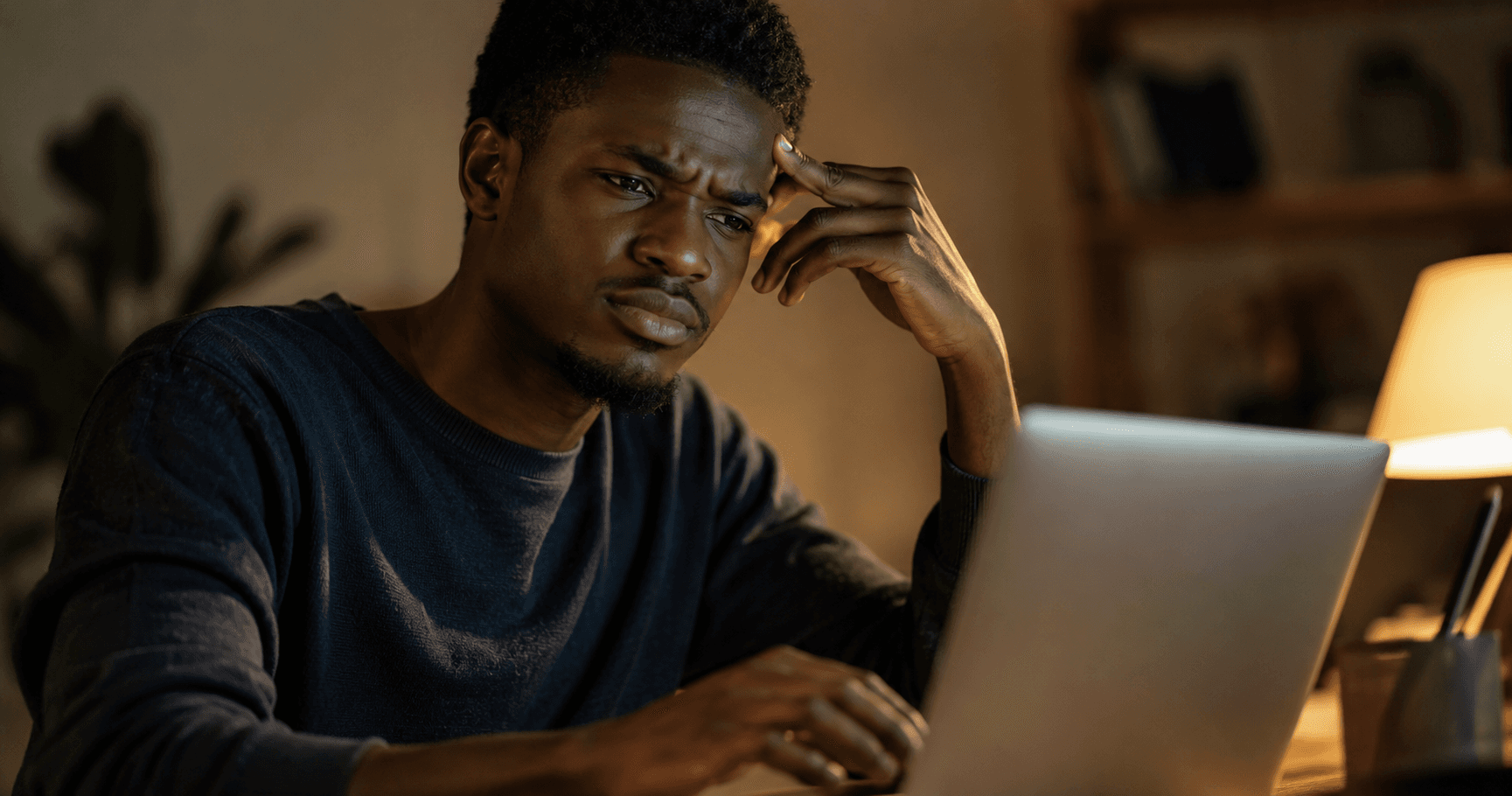 Person sitting thoughtfully at a laptop